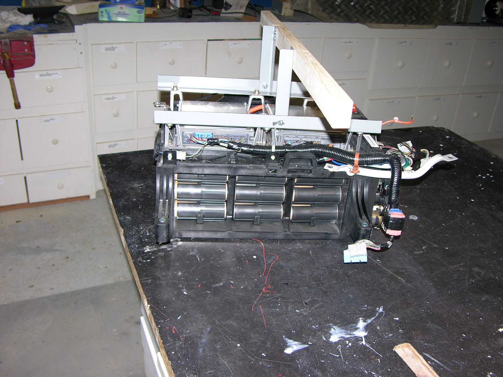 The opened IMA battery pack on a workbench with cylindrical NiMH sticks visible
